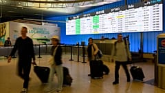 Reisende schleppen ihr Gepäck durch den internationalen Ankunftsbereich des internationalen Flughafens von Los Angeles in Los Angeles, Samstag, 8. Juni 2025.