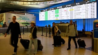 Travelers cart their luggage through the international arrivals area at the Los Angeles International Airport in Los Angeles, Saturday, June 8, 2025.