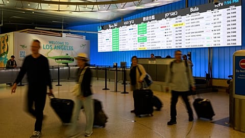 Travelers cart their luggage through the international arrivals area at the Los Angeles International Airport in Los Angeles, Saturday, June 8, 2025.
