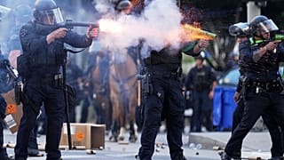 Ein Polizeibeamter feuert in der Nähe des Metropolitan Detention Center in Los Angeles am Sonntag, den 8. Juni 2025 einen leichten Schuss ab.