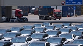 Un camion passe devant des modèles de voitures en attente d'expédition dans un centre logistique de la municipalité de Chongqing, dans le sud-ouest de la Chine. 20 mai 2025.