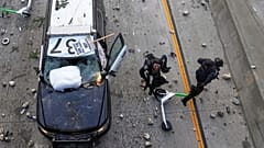 Zwei Beamte der California Highway Patrol versuchen, Steinen auszuweichen, die in der Nähe des Metropolitan Detention Centre in Los Angeles geworfen werden, Sonntag, den 8. Juni 2025.