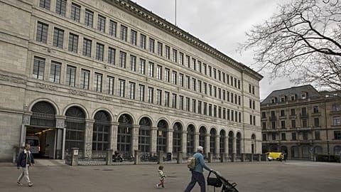 People walk past the facade of the Swiss National Bank, 