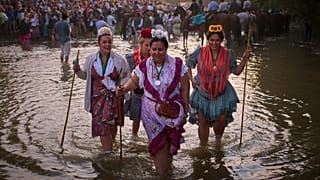 زائران از برادری تریانا روز جمعه، ۶ ژوئن ۲۰۲۵، از رودخانه کوئما در نزدیکی ازنالقصر، اسپانیا عبور می‌کنند