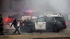 Ein Beamter der California Highway Patrol auf einem Highway, während Demonstranten in der Nähe des Metropolitan Detention Center in Los Angeles Gegenstände auf Polizeifahrzeuge werfen, Sonntag, 8. Juni 2025