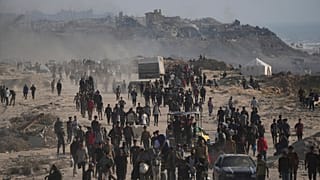 فلسطينيون نازحون يمرون بجانب أنقاض مبانٍ مدمرة على طول ساحل مدينة غزة يوم الإثنين، 9 يونيو 2025
