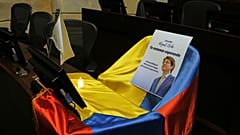 Una foto del senador colombiano Miguel Uribe Turbay y la bandera de Colombia cubren su escaño en el Congreso mientras se encuentra en estado crítico tras recibir un disparo