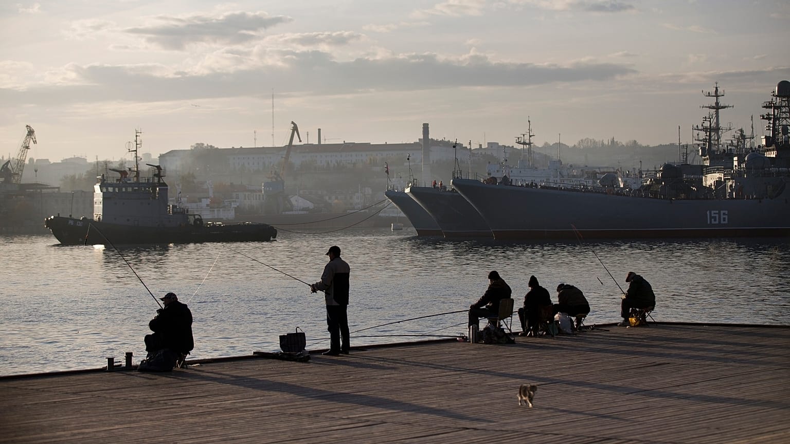Pescatori locali cercano di pescare davanti alle navi della Marina russa a Sebastopoli, in Crimea, il 27 ottobre 2014.