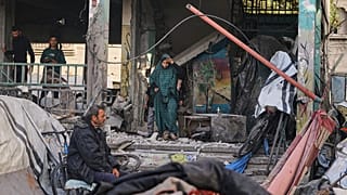 فلسطينيون يتفقدون الأضرار التي لحقت بالمدرسة التي استخدمها السكان النازحون كمأوى والتي تعرضت لغارة عسكرية إسرائيلية وأسفرت عن مقتل 36 شخصًا على الأقل، في غزة