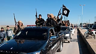 FILE - Islamic State militants drive in a convoy through Tel Abyad, northeast Syria, 4 May 2015.