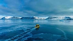 Um barco passa por uma enseada congelada nos arredores de Nuuk, na Gronelândia, a 6 de março de 2025. 