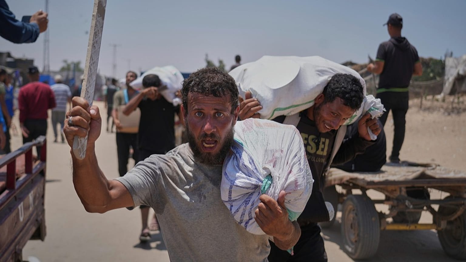 فلسطينيون يحملون مساعدات غذائية وإنسانية قدّمتها مؤسسة غزة الإنسانية المدعومة من الولايات المتحدة، في رفح جنوب قطاع غزة، الإثنين 9 حزيران/يونيو 2025.