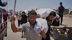فلسطينيون يحملون مساعدات غذائية وإنسانية قدّمتها مؤسسة غزة الإنسانية المدعومة من الولايات المتحدة، في رفح جنوب قطاع غزة، الإثنين 9 حزيران/يونيو 2025.