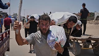فلسطينيون يحملون مساعدات غذائية وإنسانية قدّمتها مؤسسة غزة الإنسانية المدعومة من الولايات المتحدة، في رفح جنوب قطاع غزة، الإثنين 9 حزيران/يونيو 2025.
