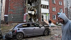 Anwohner reagieren in der Nähe ihres beschädigten mehrstöckigen Gebäudes, das bei einem Raketen- und Drohnenangriff Russlands in Kyjiw, Ukraine, am Dienstag, den zehnten Juni zweitausendfünfundzwanzig, beschädigt wurde.