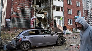 Anwohner reagieren in der Nähe ihres beschädigten mehrstöckigen Gebäudes, das bei einem Raketen- und Drohnenangriff Russlands in Kyjiw, Ukraine, am Dienstag, den zehnten Juni zweitausendfünfundzwanzig, beschädigt wurde.