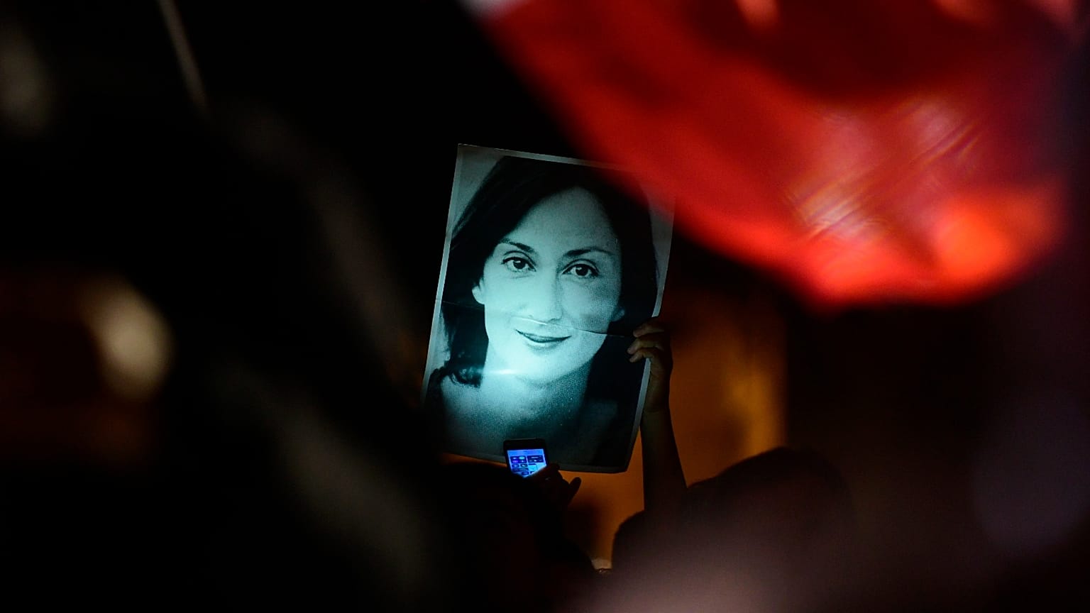 Un manifestante tiene una foto della reporter uccisa Daphne Caruana Galizia durante una manifestazione davanti all'ufficio del primo ministro a La Valletta, 27 novembre 2019.