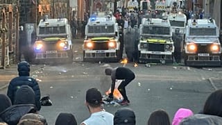 هذه الصورة مأخوذة من فيديو وكالة أسوشيتد برس، تغلق عربات شرطة مكافحة الشغب طريقًا في كلونافون تيراس، في بليمينا، أيرلندا الشمالية، بينما يشارك الناس في احتجاج على اعتداء جنس
