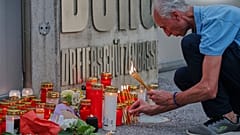 Mężczyzna zapala świece przy wejściu do szkoły po śmiertelnej strzelaninie, do której doszło tam w Grazu w Austrii, wtorek, 10 czerwca 2025 r. (AP Photo/Heinz-Peter Bader)