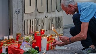 Mężczyzna zapala świece przy wejściu do szkoły po śmiertelnej strzelaninie, do której doszło tam w Grazu w Austrii, wtorek, 10 czerwca 2025 r. (AP Photo/Heinz-Peter Bader)