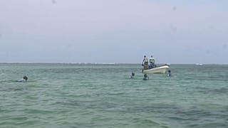 Trabalhadores da guarda costeira do Djibuti procuram corpos de migrantes que foram arrastados pela correnteza na costa do Mar Vermelho, 2 de outubro de 2024