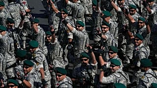 أفراد من الجيش الإيراني يرفعون علامة النصر أثناء اختتام مسيرتهم خلال عرض عسكري، إيران، الجمعة 18 أبريل/نيسان 2025.  