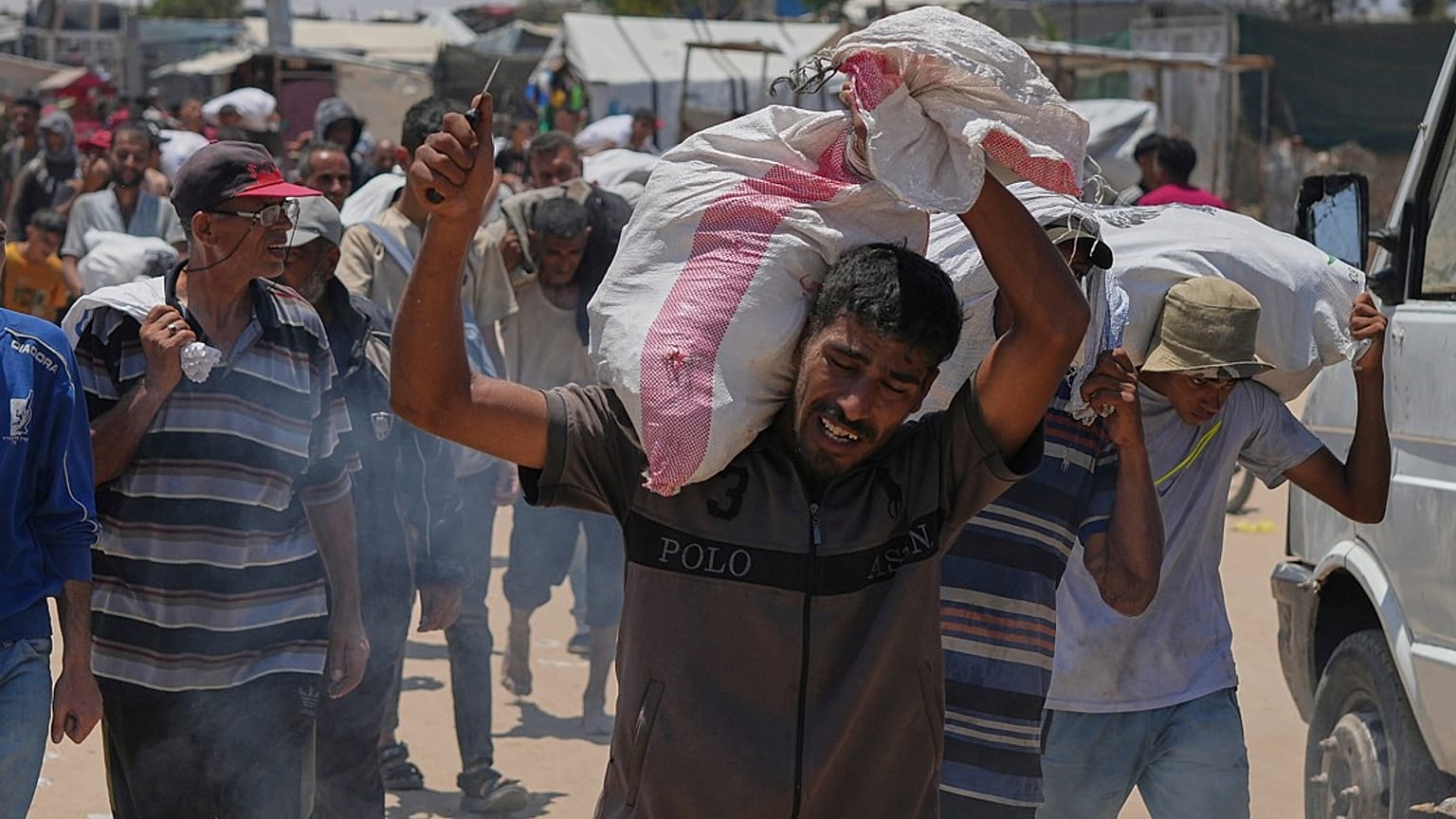  فلسطيني يحمل حقيبة تحتوي على طعام ومساعدات إنسانية، في رفح، جنوب قطاع غزة، الأربعاء 11 يونيو/حزيران 2025.  