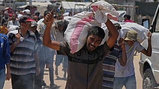 فلسطيني يحمل حقيبة تحتوي على طعام ومساعدات إنسانية، في رفح، جنوب قطاع غزة، الأربعاء 11 يونيو/حزيران 2025.
