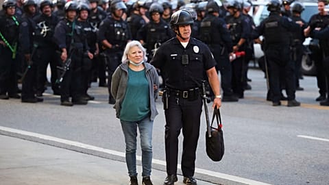 Un agent des forces de l'ordre escorte une femme hors d'une manifestation après qu'elle a été arrêtée le mercredi 11 juin 2025, à Los Angeles