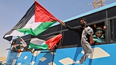 En az 1.500 kişiden oluşan bir insani yardım konvoyunun üyeleri Zaviye'de Gazze'ye doğru ilerlerken bir otobüsten Filistin bayrakları sallıyor, 10 Haziran 2025
