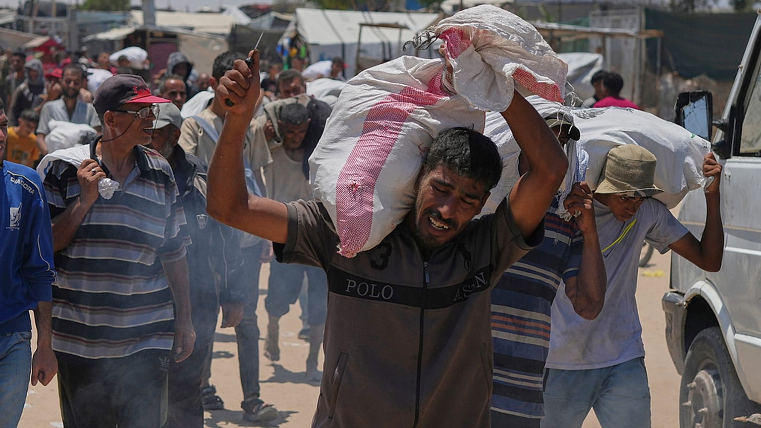 فلسطيني يحمل كيسًا يحتوي على مواد غذائية ومساعدات إنسانية قدمتها مؤسسة غزة الإنسانية، وهي منظمة مدعومة من الولايات المتحدة، في رفح، جنوب قطاع غزة، الأربعاء، 11 يونيو 2025