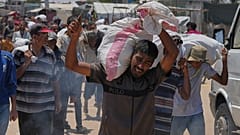 فلسطيني يحمل كيسًا يحتوي على مواد غذائية ومساعدات إنسانية قدمتها مؤسسة غزة الإنسانية، وهي منظمة مدعومة من الولايات المتحدة، في رفح، جنوب قطاع غزة، الأربعاء، 11 يونيو 2025
