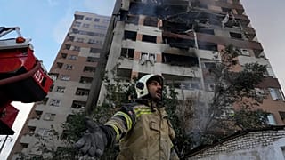 Пожарный окликает своих коллег на месте взрыва в жилом комплексе на севере Тегерана, Иран. 13 июня 2025 года.
