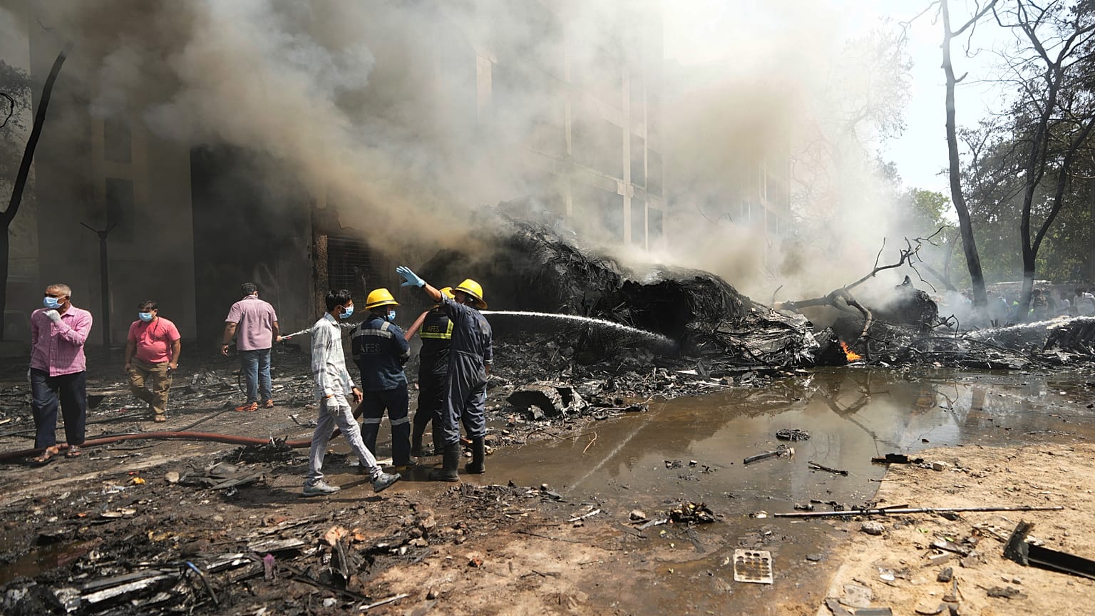 Tűzoltók dolgoznak az indai repülőgép-katasztrófa után