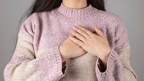 A woman holds her hand to her heart.