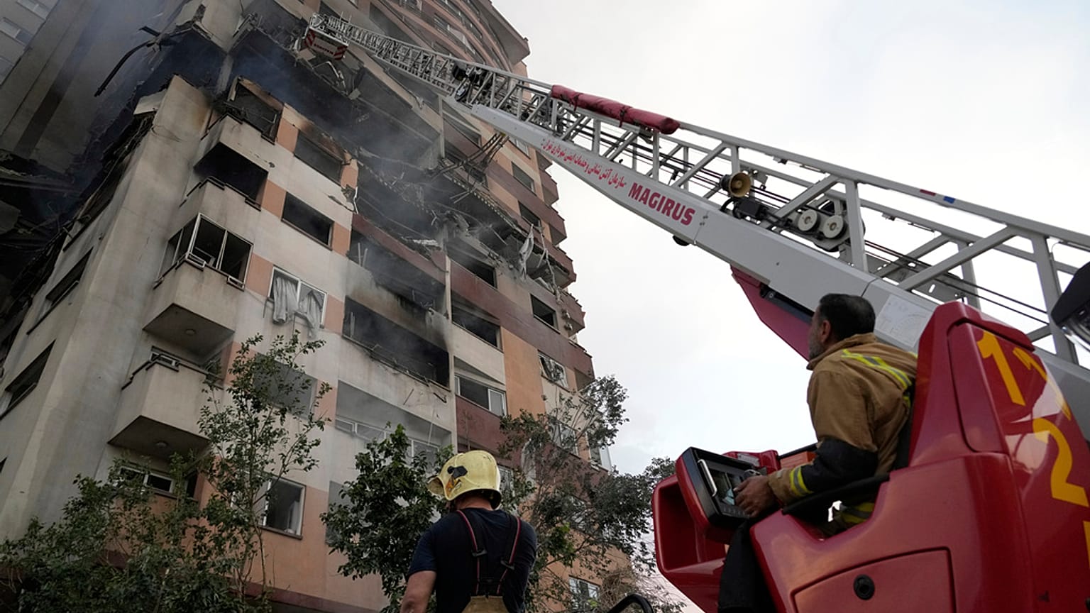رجال الإطفاء يعملون في موقع انفجار وقع في مجمع سكني في شمال طهران، إيران، الجمعة، 13 يونيو 2025