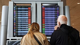Des passagers regardent l'écran affichant les vols retardés à l'aéroport Ben Gurion, près de Tel Aviv, en Israël.