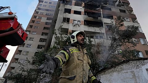 Un pompier appelle ses collègues sur les lieux d'une explosion dans un complexe résidentiel au nord de Téhéran, en Iran, le vendredi 13 juin 2025