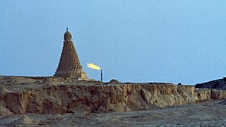 مسجد قديم وشعلة مصنع للبتروكيماويات يحرقان نواتج الغاز غير المرغوب فيها في جزيرة خرج، إيران، يوليو 1971. 