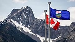 Eine kanadische Flagge (links) und eine Flagge von Alberta flattern im Wind, im Hintergrund der Wedge Mountain am Ort des G7-Treffens der Staats- und Regierungschefs in Kananaskis, Alberta, am 2. Juni 2025.