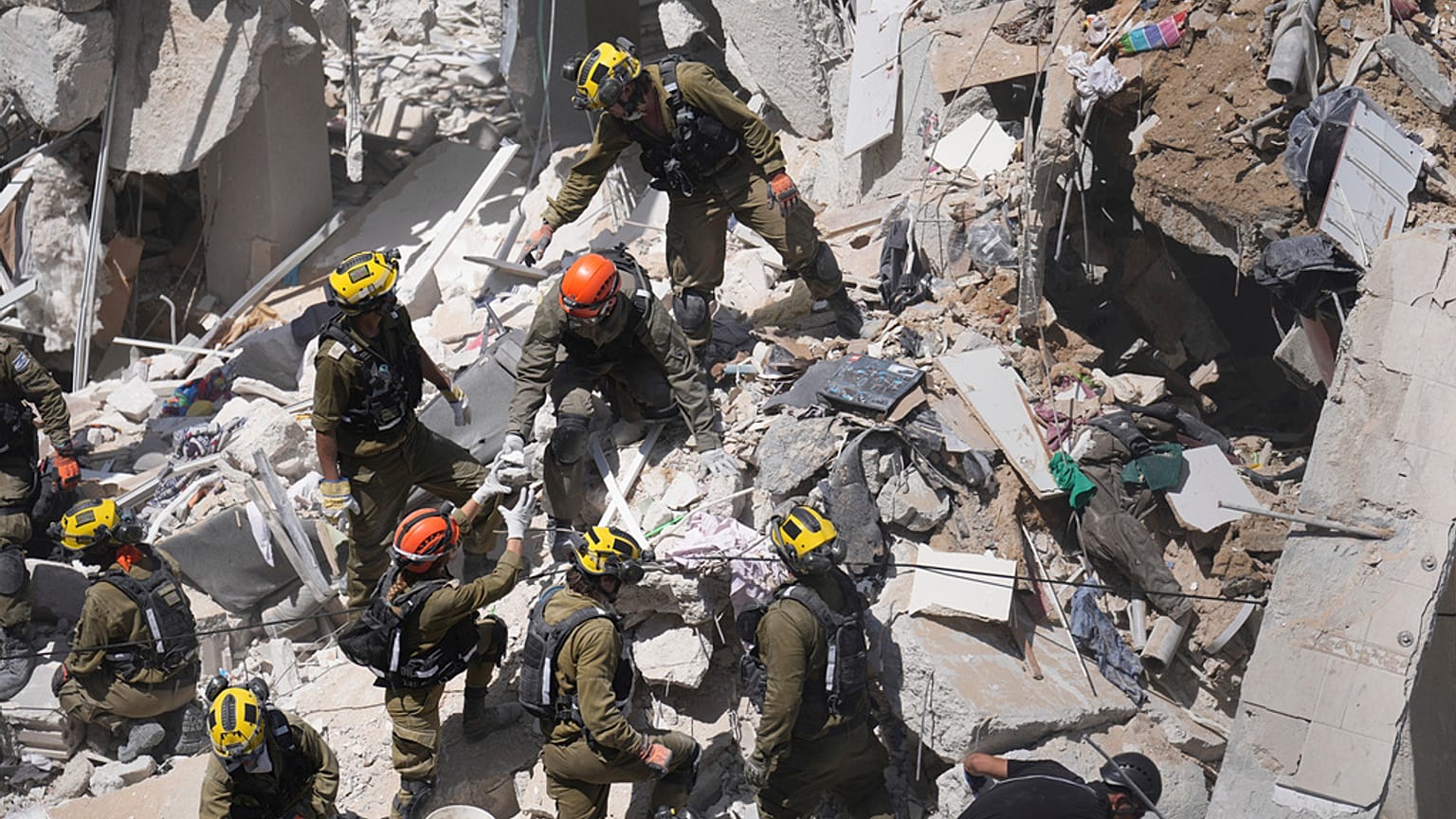 Soldados israelíes excavan entre los escombros en busca de sobrevivientes en la localidad de Bat Jam, en el centro de Israel.