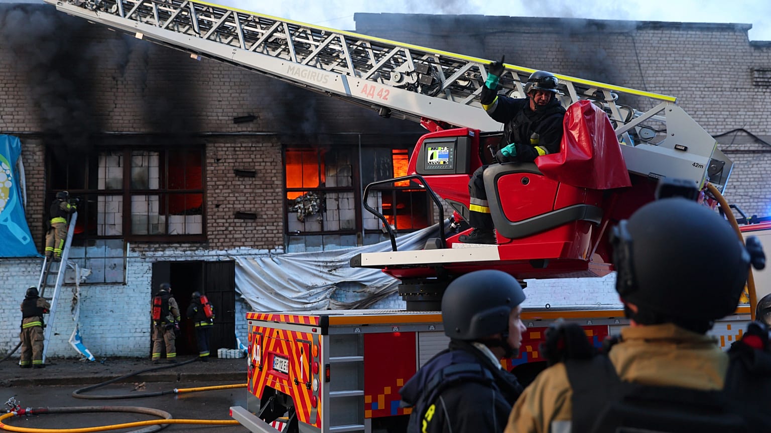 Des secouristes éteignent l'incendie d'un entrepôt d'aide humanitaire détruit par une frappe de drone russe à Zaporijjia, en Ukraine, le samedi 14 juin 2025