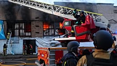 Des secouristes éteignent l'incendie d'un entrepôt d'aide humanitaire détruit par une frappe de drone russe à Zaporijjia, en Ukraine, le samedi 14 juin 2025