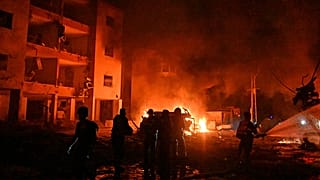 Пожарные ведут борьбу с огнем после того, как ракета, запущенная из Ирана, упала в Хайфе. 15 июня 2025 г.