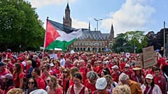 Dezenas de milhares de manifestantes vestidos de vermelho passaram pelo Palácio da Paz durante uma manifestação em Haia, Holanda, no domingo, 15 de junho de 2025.