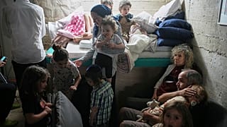 Israeliani si rifugiano in un bunker dopo il suono di una sirena che avverte del lancio di razzi dall'Iran, a Gerusalemme, domenica 15 giugno 2025.