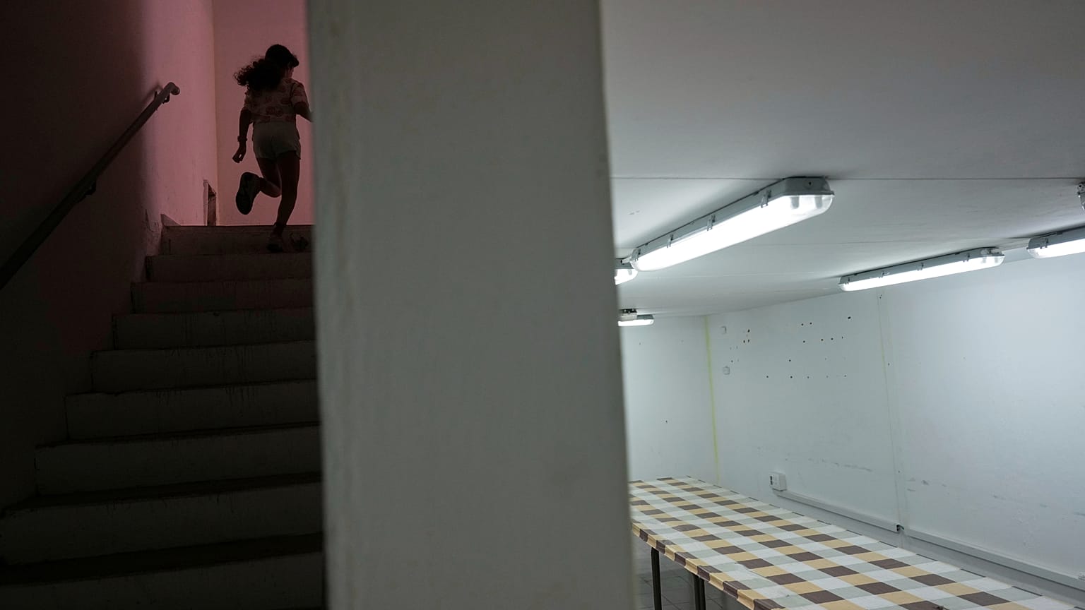 A girl runs to a bomb shelter in an apartment building in Hadera, 13 June 2025