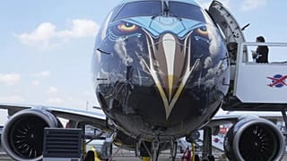 Человек стоит у самолета Embraer E2 на Парижском авиасалоне, понедельник, 16 июня 2025 года, в Ле Бурже, к северу от Парижа.