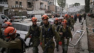 A Honvédelmi Parancsnokság egységének katonája megérkezik arra a helyszínre, ahol egy iráni rakéta csapódott be Bnei Brakban, Tel-Aviv közelében, Izraelben, 2025. június 16-án, hétfőn.