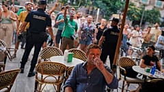 Touristen sitzen in einem Terrassenrestaurant bei einer Demonstration gegen den Übertourismus auf der Baleareninsel Mallorca in Spanien am Sonntag, den 15. Juni 2025.
